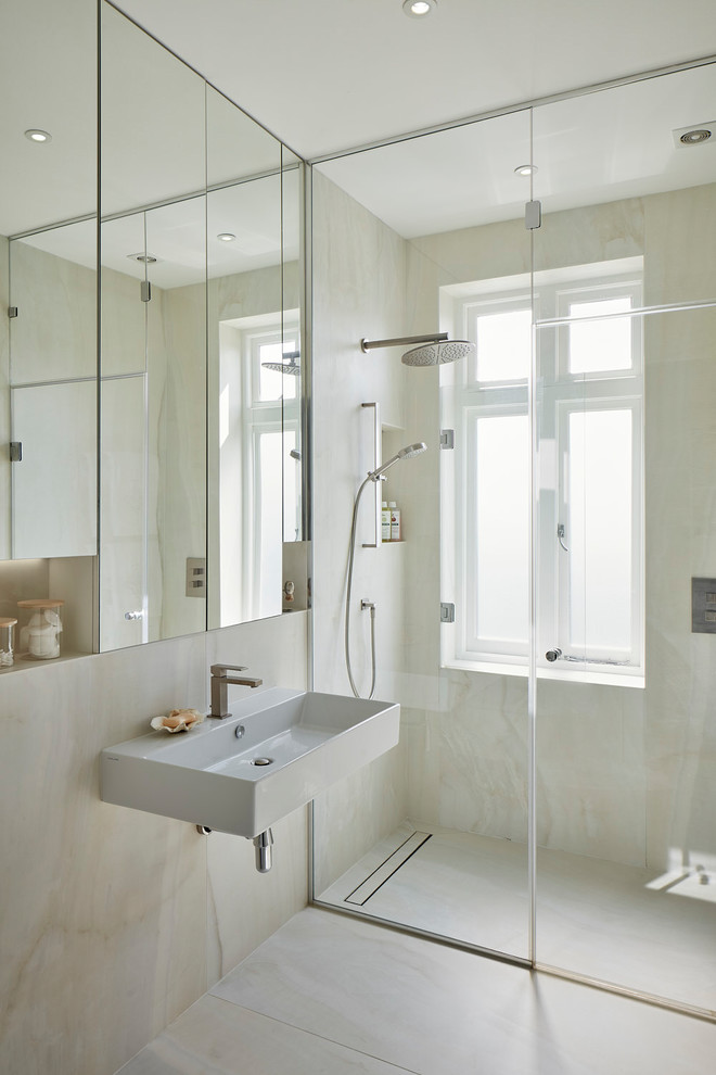 Aménagement d'une salle d'eau contemporaine avec une douche à l'italienne, un carrelage beige, un mur beige, un lavabo suspendu, un sol beige et une fenêtre.
