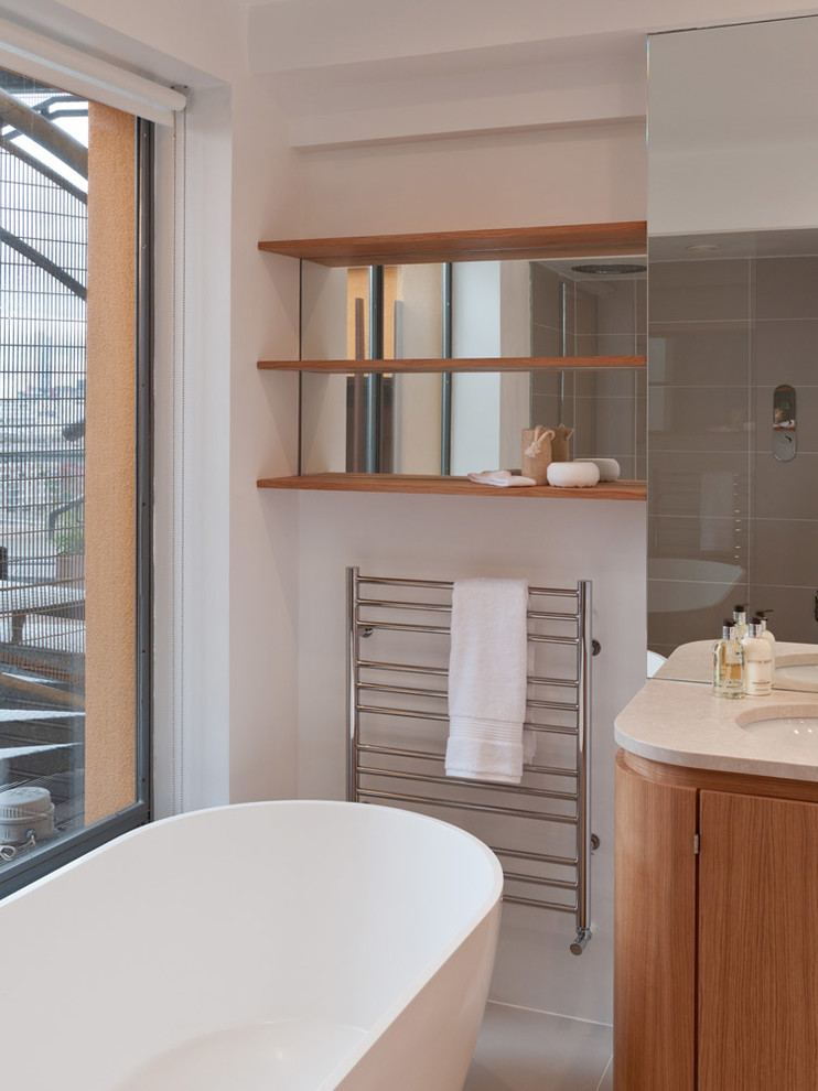 Modelo de cuarto de baño contemporáneo con bañera exenta, ducha empotrada, baldosas y/o azulejos grises y baldosas y/o azulejos de piedra