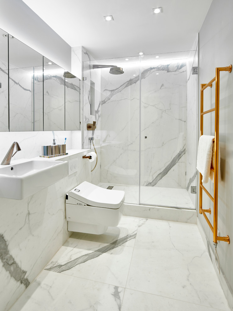 Bild på ett mellanstort funkis en-suite badrum, med luckor med glaspanel, vita skåp, en öppen dusch, en vägghängd toalettstol, svart och vit kakel, porslinskakel, vita väggar, klinkergolv i porslin, ett väggmonterat handfat och kaklad bänkskiva