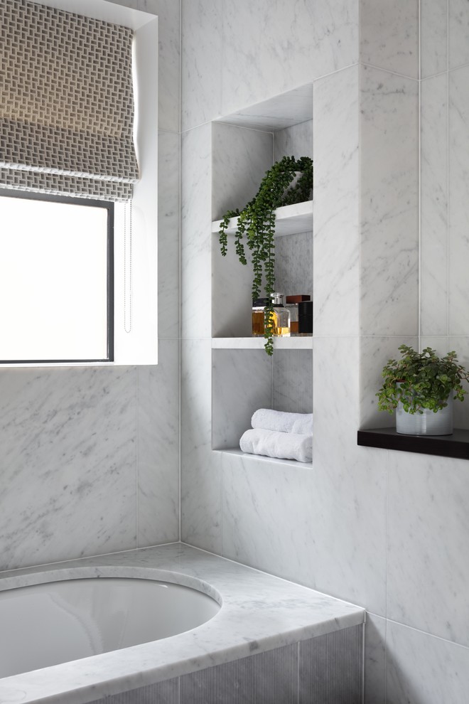 Design ideas for a contemporary ensuite bathroom in London with flat-panel cabinets, black cabinets, a built-in bath, a walk-in shower, a one-piece toilet, white tiles, marble tiles, marble flooring, a submerged sink, engineered stone worktops, an open shower and black worktops.