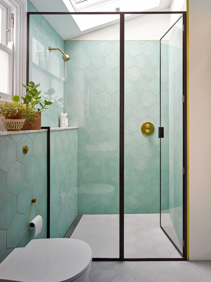 Cette image montre une salle de bain design de taille moyenne avec une douche ouverte, WC à poser, des carreaux de céramique, un mur vert, un sol en carrelage de céramique, un sol gris et une cabine de douche à porte battante.