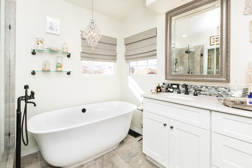 Bild på ett mellanstort shabby chic-inspirerat en-suite badrum, med vita skåp, ett fristående badkar, flerfärgad kakel, vita väggar, klinkergolv i keramik, ett undermonterad handfat, bänkskiva i kvarts, skåp i shakerstil och mosaik