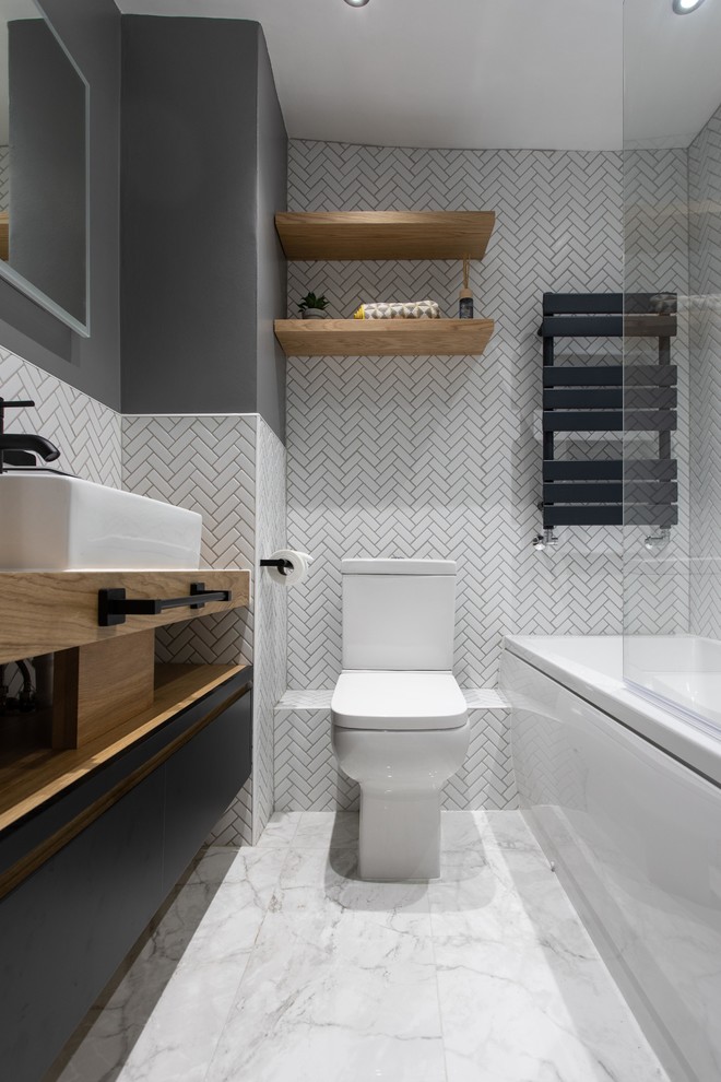 Drop-in bathtub - mid-sized modern kids' cement tile cement tile floor drop-in bathtub idea in London with a bidet, gray walls, a vessel sink and a hinged shower door
