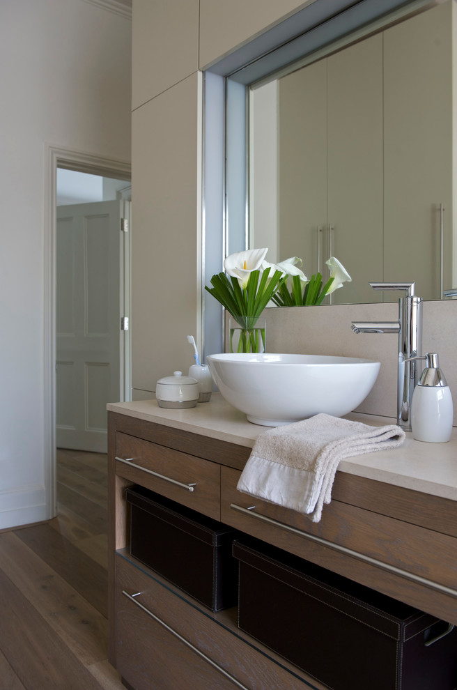 Modernes Badezimmer mit Waschtischkonsole und braunem Holzboden in London