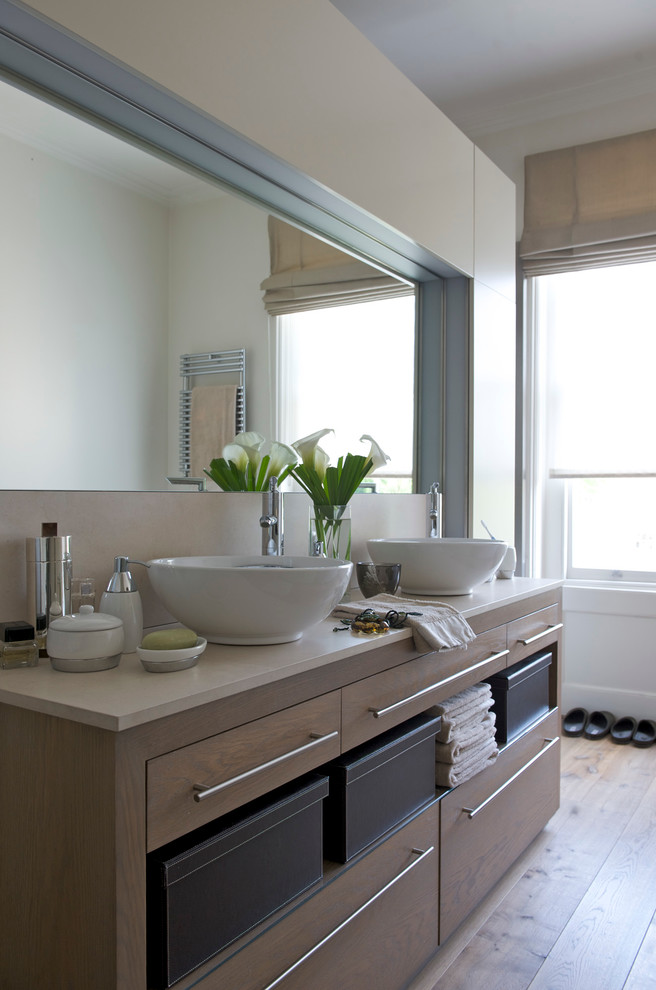This is an example of a contemporary ensuite bathroom in London with a console sink and medium hardwood flooring.