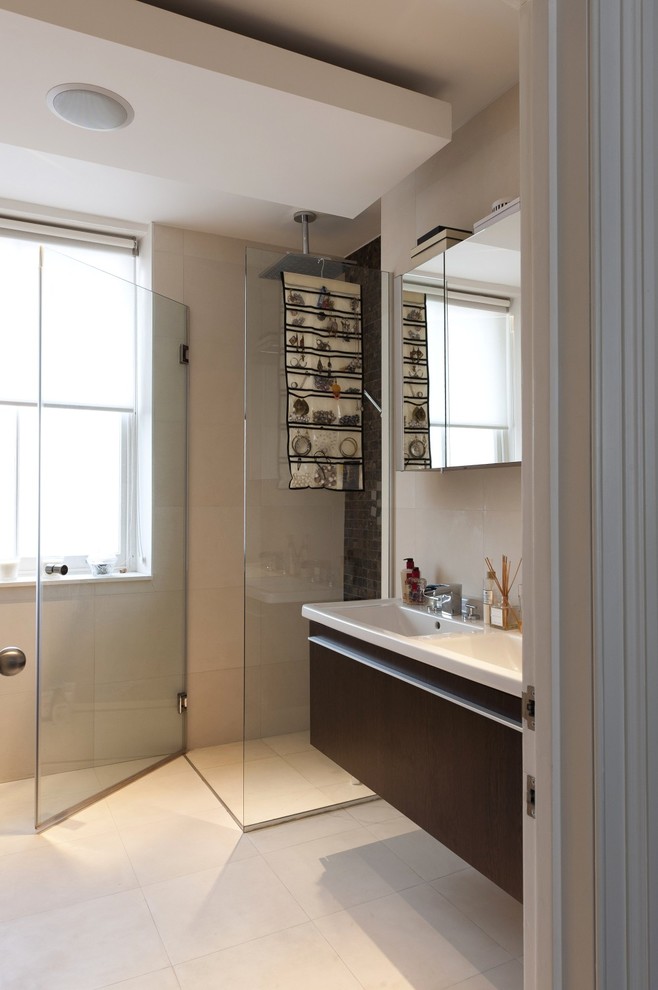 This is an example of a traditional ensuite bathroom in London with flat-panel cabinets, dark wood cabinets, a corner shower, white tiles, an integrated sink, solid surface worktops, white floors and a hinged door.