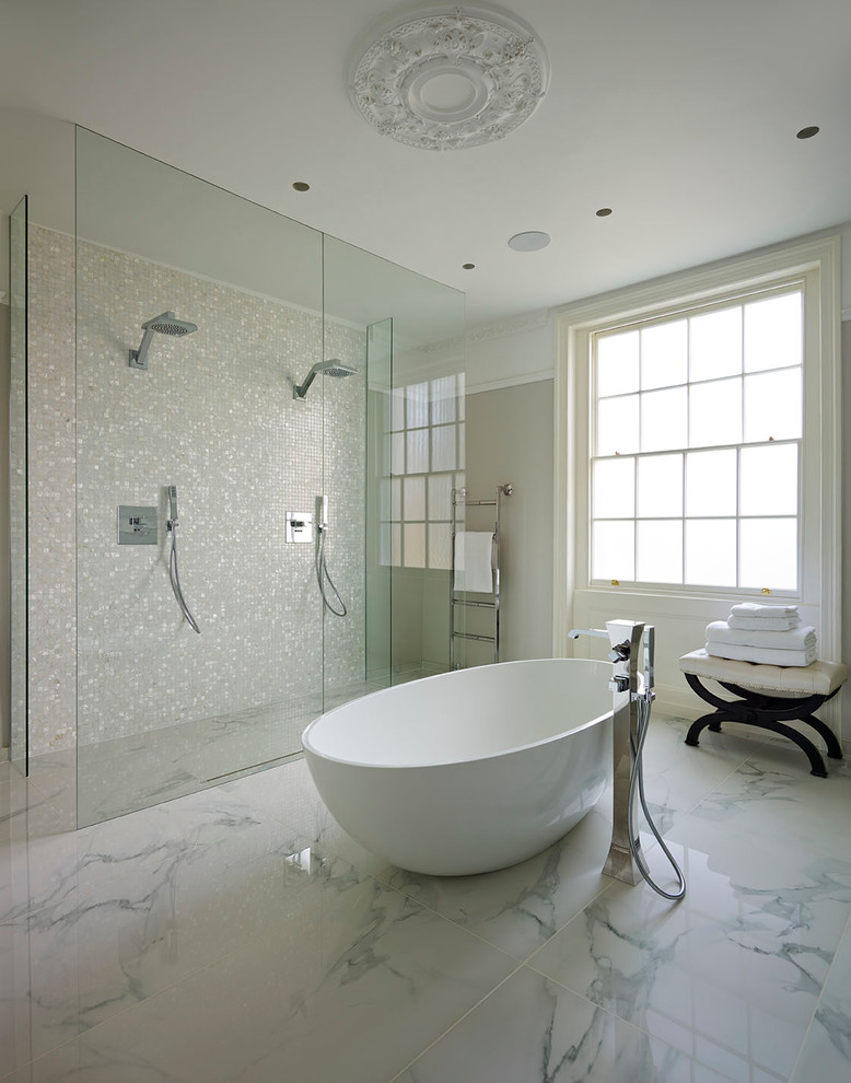 На фото: главная ванная комната в стиле неоклассика (современная классика) с отдельно стоящей ванной, бежевой плиткой, серыми стенами и мраморным полом с