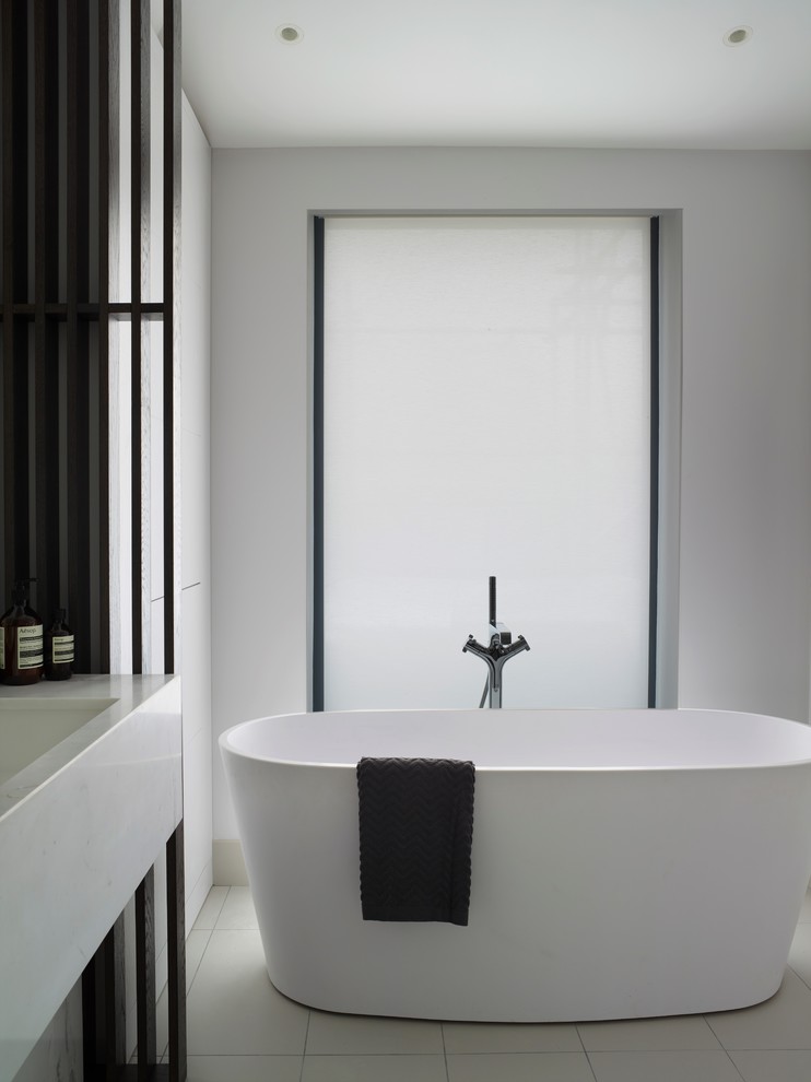 Esempio di una grande stanza da bagno padronale contemporanea con ante lisce, ante blu, WC sospeso, piastrelle di marmo, pareti gialle, top in marmo, pavimento grigio e top bianco