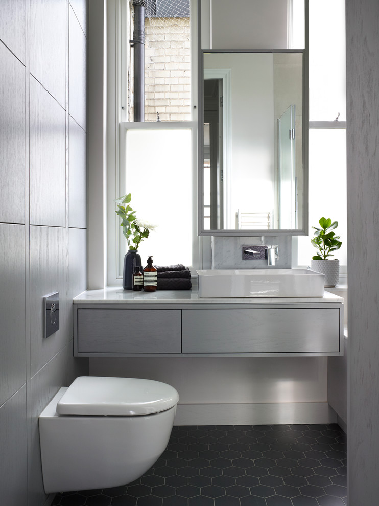 Foto di una grande stanza da bagno padronale contemporanea con ante lisce, ante blu, WC sospeso, piastrelle di marmo, pareti gialle, top in marmo, pavimento grigio e top bianco