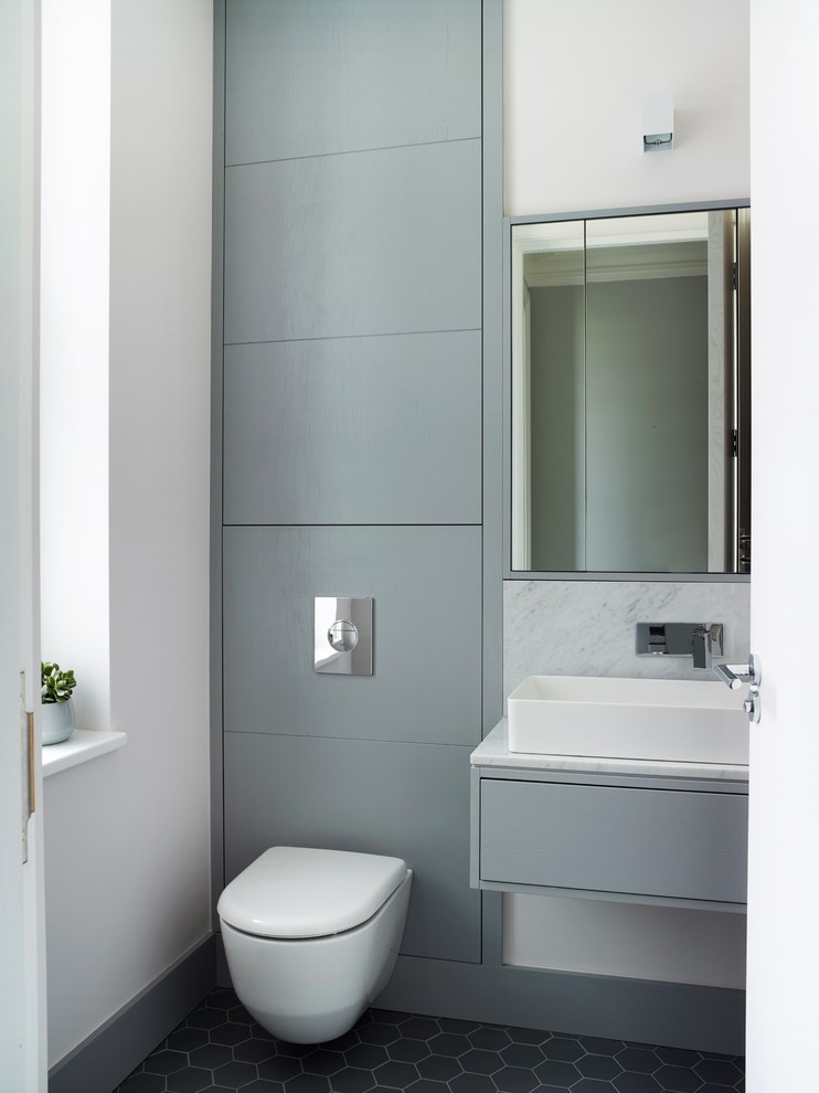 Foto di una grande stanza da bagno padronale design con ante lisce, ante blu, WC sospeso, piastrelle di marmo, pareti gialle, top in marmo, pavimento grigio e top bianco