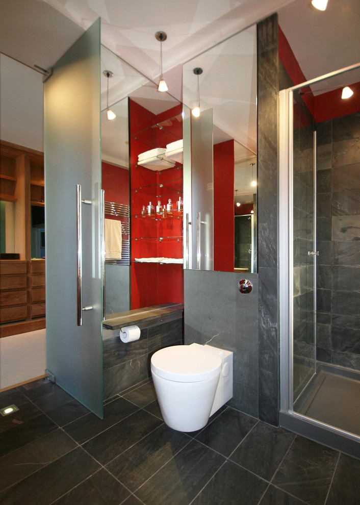 Inspiration för små moderna badrum med dusch, med en dusch i en alkov, en vägghängd toalettstol, grå kakel, stenhäll, röda väggar och skiffergolv