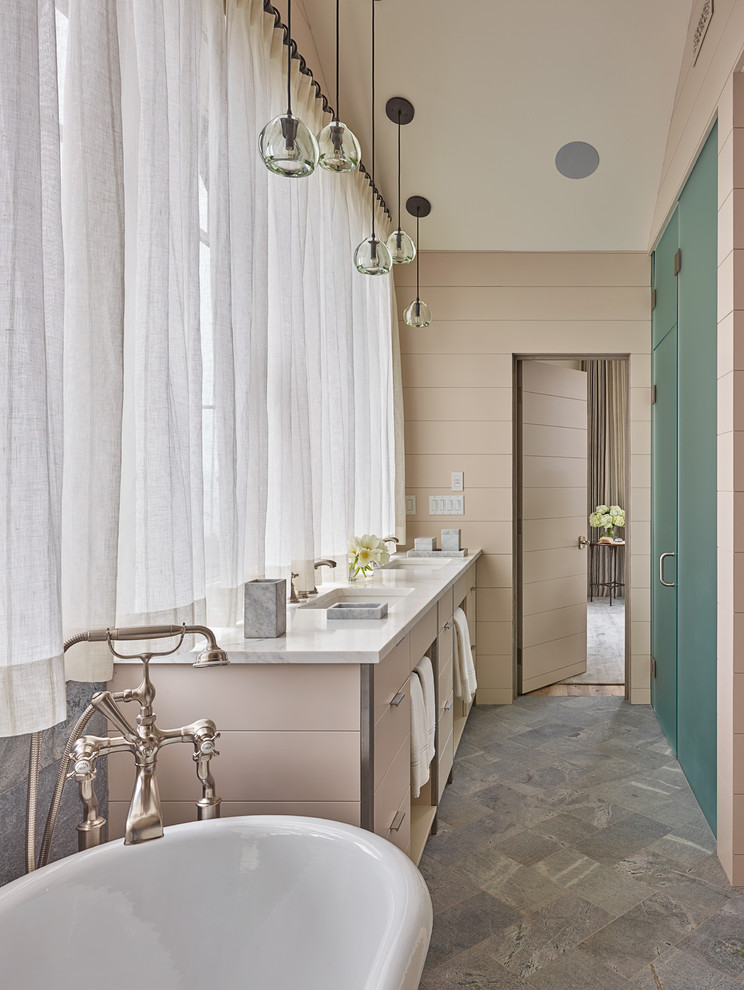 Inredning av ett klassiskt stort en-suite badrum, med släta luckor, beige skåp, beige kakel, ett undermonterad handfat, ett fristående badkar, en kantlös dusch, stenkakel, beige väggar, skiffergolv och marmorbänkskiva