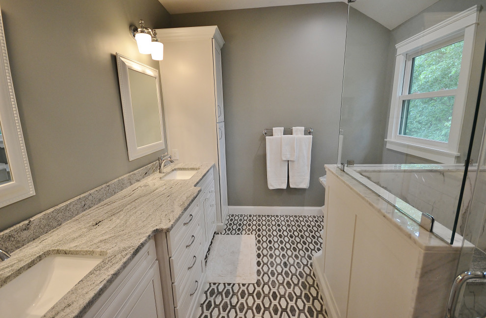 Стильный дизайн: большая главная ванная комната в стиле неоклассика (современная классика) с фасадами с выступающей филенкой, белыми фасадами, угловым душем, унитазом-моноблоком, разноцветной плиткой, мраморной плиткой, серыми стенами, полом из мозаичной плитки, врезной раковиной, столешницей из гранита, разноцветным полом, душем с распашными дверями, разноцветной столешницей, сиденьем для душа, тумбой под две раковины и встроенной тумбой - последний тренд