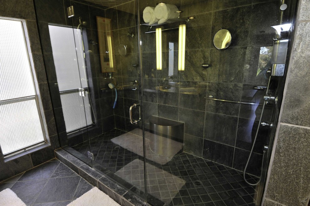 Inredning av ett modernt stort en-suite badrum, med en dusch i en alkov, grå kakel, stenkakel, grå väggar, klinkergolv i keramik, ett integrerad handfat, svart golv och dusch med gångjärnsdörr