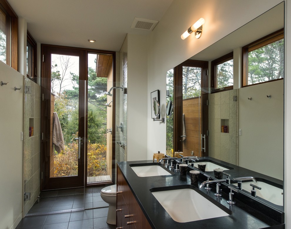 Bathroom - mid-sized 1950s master beige tile and stone tile porcelain tile and black floor bathroom idea in Boston with an undermount sink, flat-panel cabinets, medium tone wood cabinets, white walls, quartz countertops and a hinged shower door
