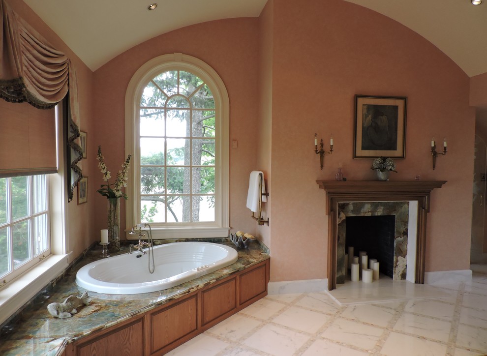 На фото: большая главная ванная комната в классическом стиле с фасадами с выступающей филенкой, фасадами цвета дерева среднего тона, столешницей из оникса, угловой ванной, белой плиткой, плиткой мозаикой, оранжевыми стенами и мраморным полом