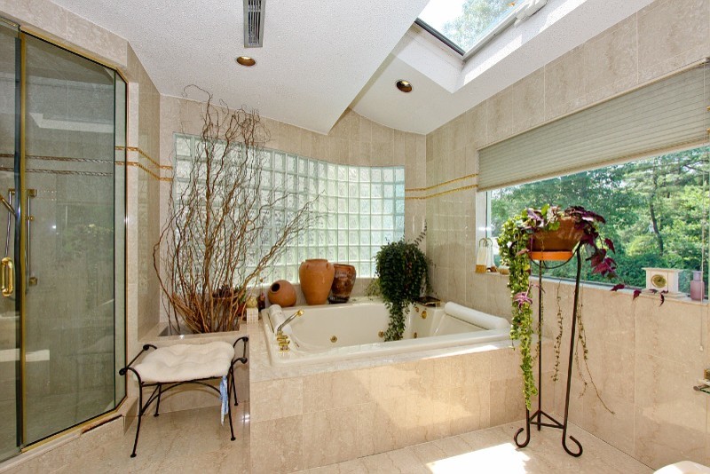 На фото: главная ванная комната в стиле фьюжн с накладной ванной, угловым душем, бежевой плиткой и бежевыми стенами с