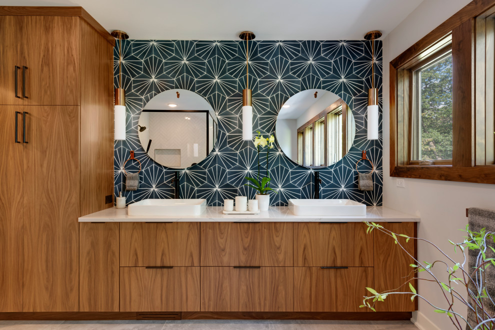 Photo of a large retro ensuite bathroom in Minneapolis with flat-panel cabinets, dark wood cabinets, a japanese bath, a corner shower, a two-piece toilet, blue tiles, porcelain tiles, white walls, porcelain flooring, a submerged sink, quartz worktops, grey floors, a hinged door, white worktops, an enclosed toilet, double sinks and a built in vanity unit.