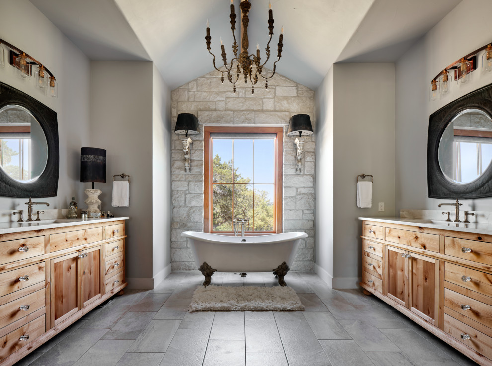 Example of a country master gray floor, double-sink and vaulted ceiling claw-foot bathtub design in Other with shaker cabinets, light wood cabinets, gray walls, an undermount sink, white countertops and a built-in vanity