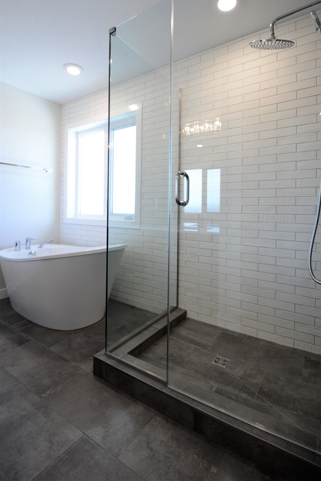 Aménagement d'une salle de bain principale classique de taille moyenne avec une baignoire indépendante, une douche d'angle, un carrelage blanc, un carrelage métro, un mur blanc, un sol marron et une cabine de douche à porte battante.