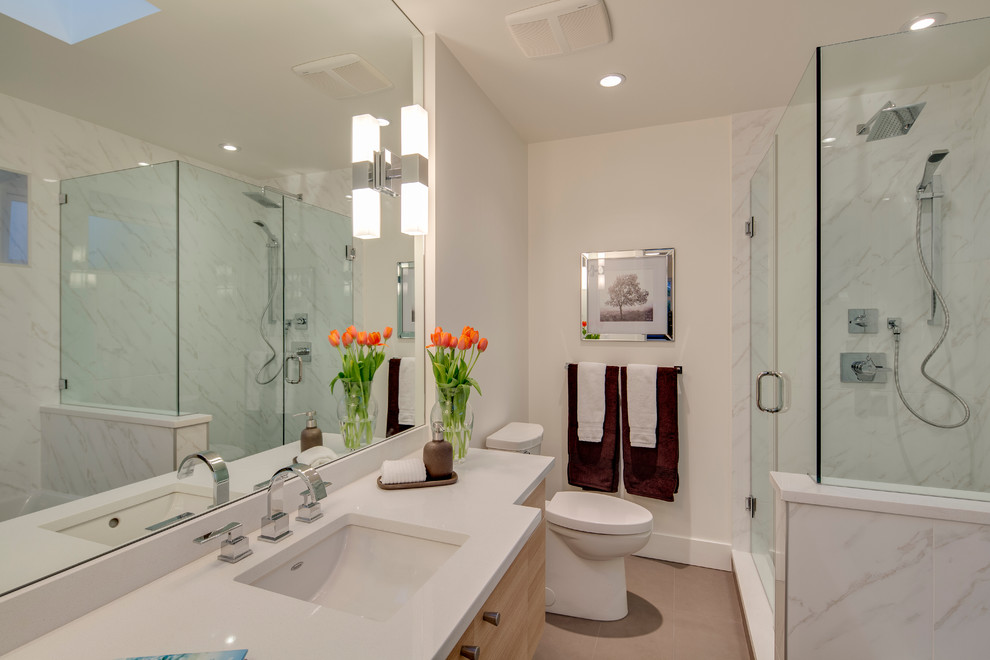 Imagen de cuarto de baño principal actual pequeño con lavabo bajoencimera, armarios con paneles lisos, puertas de armario de madera clara, encimera de cuarzo compacto, ducha esquinera y paredes blancas