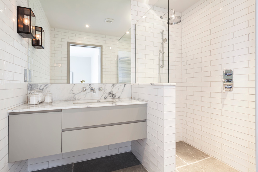 Esempio di una stanza da bagno design di medie dimensioni con lavabo sottopiano, ante lisce, ante grigie, top in marmo, doccia ad angolo, piastrelle bianche e piastrelle diamantate