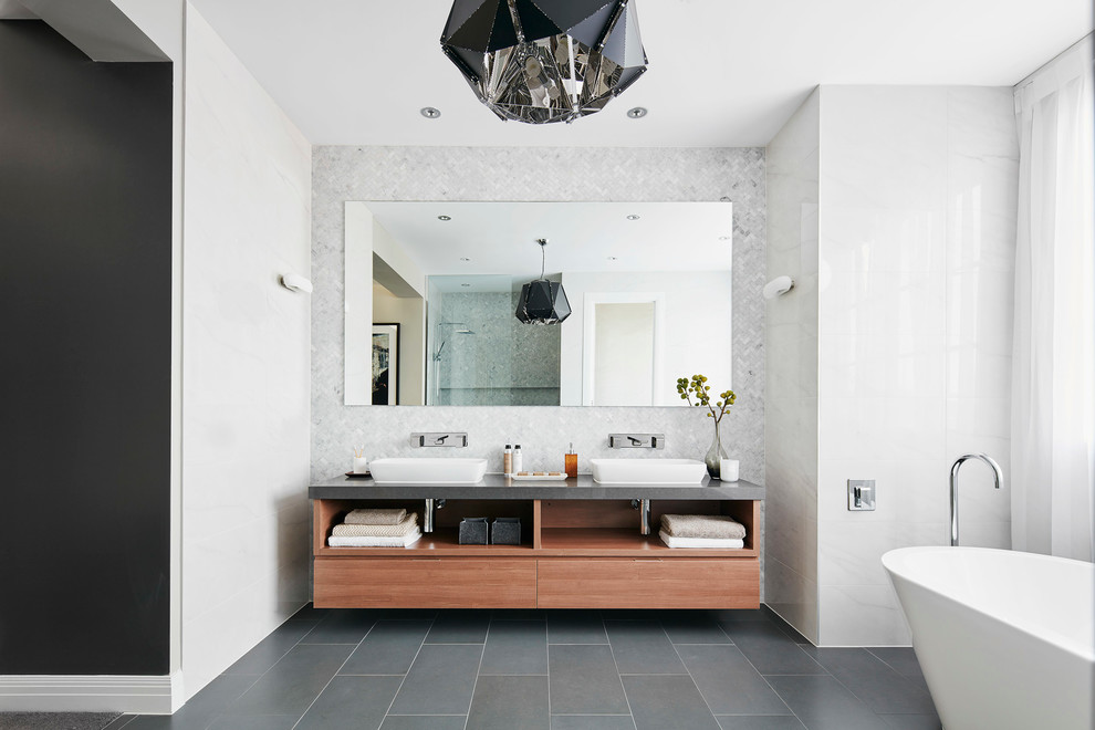 Imagen de cuarto de baño rectangular contemporáneo grande con bañera exenta, lavabo sobreencimera y suelo gris