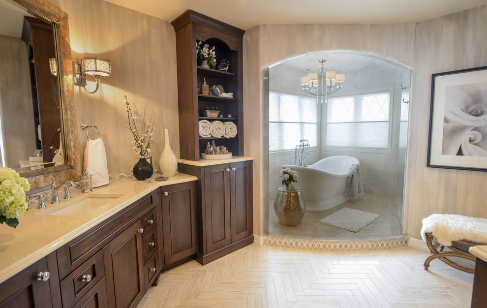 Идея дизайна: ванная комната в классическом стиле с плоскими фасадами, темными деревянными фасадами, отдельно стоящей ванной, бежевой плиткой, серой плиткой, серыми стенами, полом из известняка, врезной раковиной и мраморной столешницей