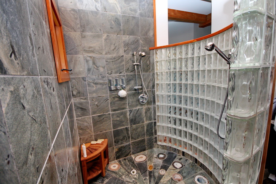 Imagen de cuarto de baño rústico con ducha abierta y baldosas y/o azulejos grises