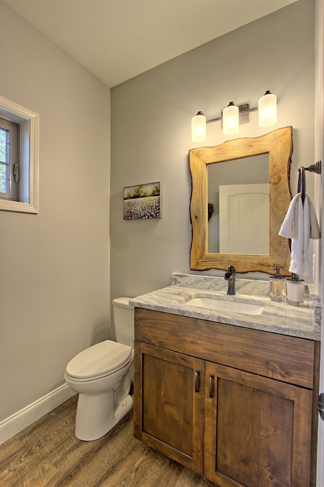 Aménagement d'une petite salle de bain craftsman en bois brun avec un placard à porte shaker, WC séparés, un mur gris, un sol en vinyl, un lavabo encastré, un plan de toilette en granite, un sol marron et un plan de toilette multicolore.