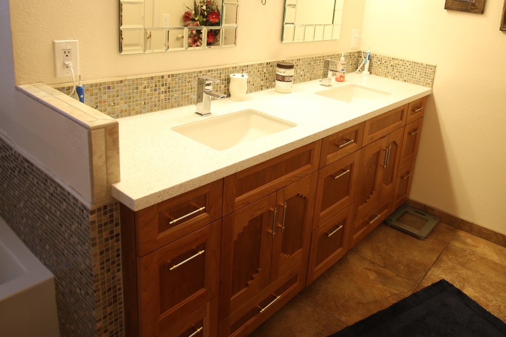 Exemple d'une petite salle de bain principale sud-ouest américain en bois brun avec un placard avec porte à panneau encastré, mosaïque, un mur beige, un sol en travertin, un lavabo encastré, un plan de toilette en surface solide, une baignoire en alcôve et un sol marron.