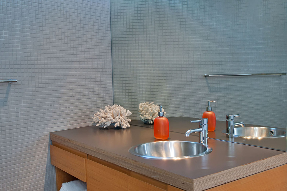Ispirazione per una stanza da bagno contemporanea con lavabo da incasso, ante in legno scuro, piastrelle grigie e piastrelle a mosaico