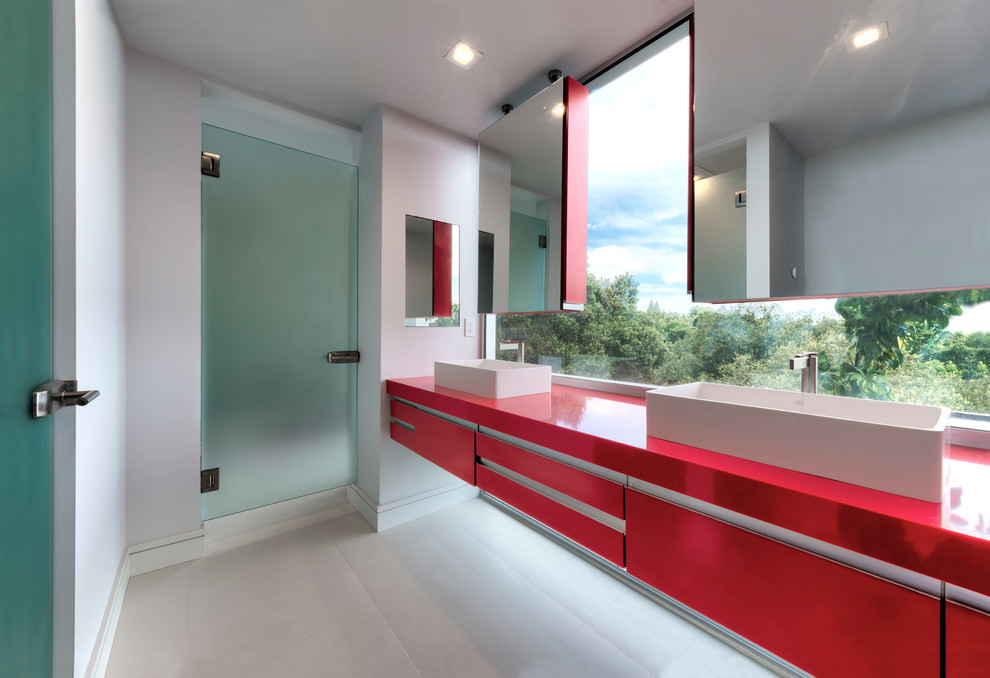 На фото: детская ванная комната среднего размера в современном стиле с плоскими фасадами, красными фасадами, двойным душем, белыми стенами, полом из керамической плитки, врезной раковиной, белым полом, душем с распашными дверями, столешницей из искусственного камня и красной столешницей