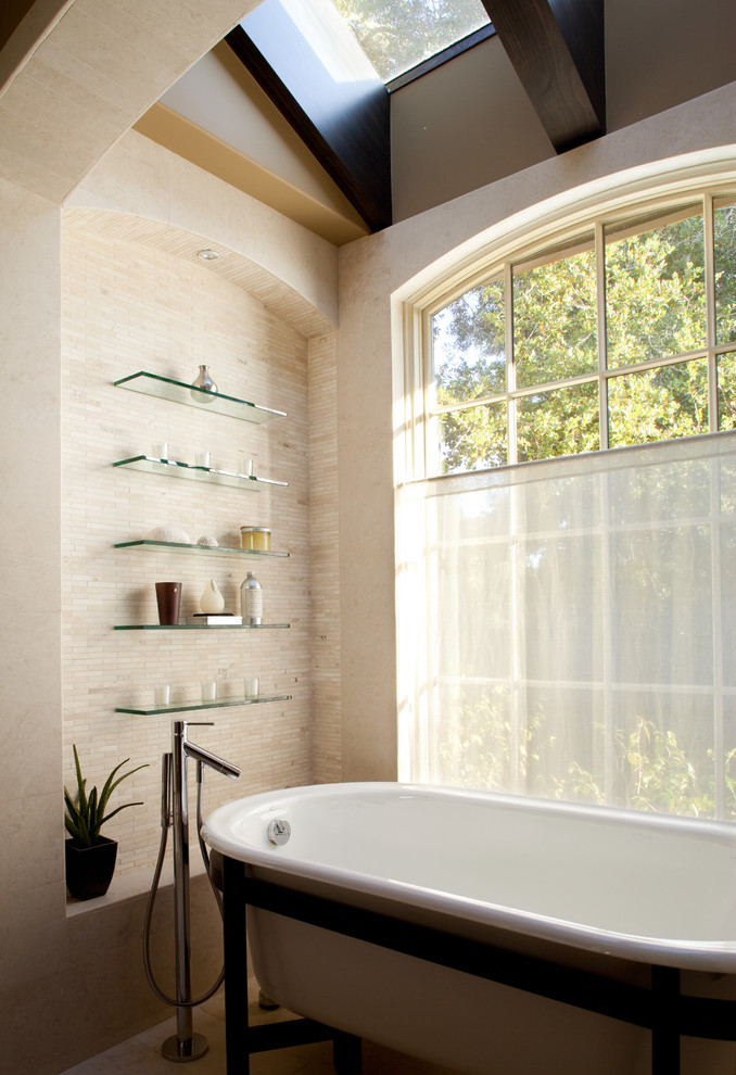 Exempel på ett stort medelhavsstil en-suite badrum, med öppna hyllor, bänkskiva i glas, ett fristående badkar, beige kakel, beige väggar och glaskakel
