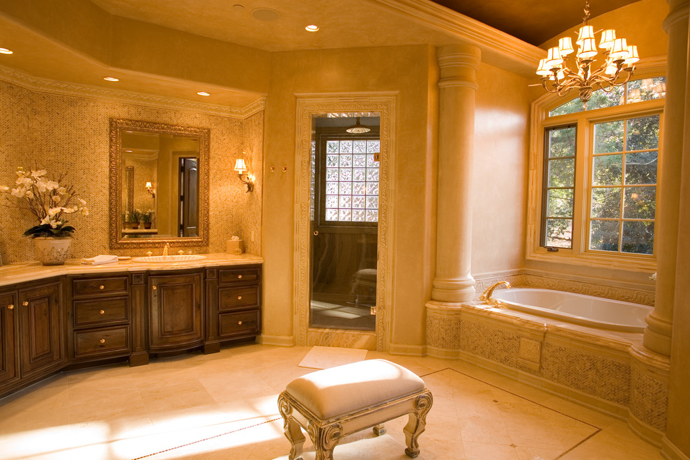 Свежая идея для дизайна: большая главная ванная комната в средиземноморском стиле с фасадами с выступающей филенкой, темными деревянными фасадами, накладной ванной, душем в нише, бежевыми стенами и накладной раковиной - отличное фото интерьера