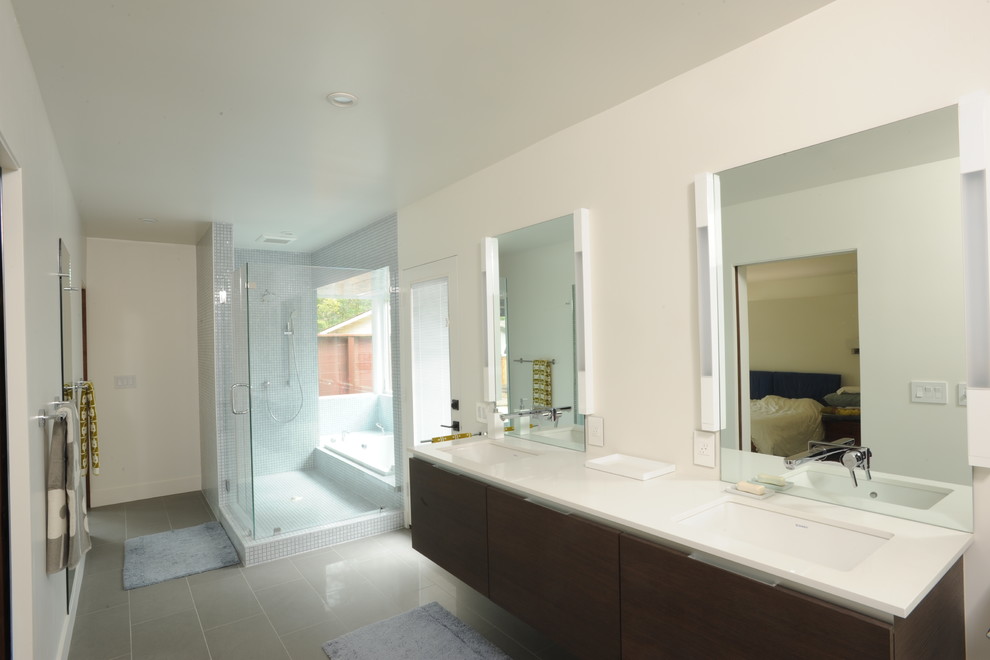 На фото: большая главная ванная комната в стиле модернизм с плоскими фасадами, темными деревянными фасадами, накладной ванной, угловым душем, синей плиткой, плиткой мозаикой, белыми стенами, полом из керамогранита, врезной раковиной и столешницей из искусственного камня с