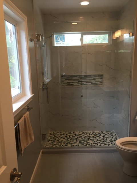 Modern ensuite bathroom in San Francisco with a submerged sink, recessed-panel cabinets, black cabinets, quartz worktops, a one-piece toilet, multi-coloured tiles, stone tiles, grey walls and ceramic flooring.