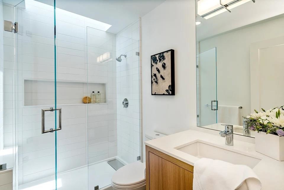 Photo of a medium sized modern shower room bathroom in San Francisco with flat-panel cabinets, brown cabinets, an alcove shower, a two-piece toilet, white tiles, porcelain tiles, white walls, porcelain flooring, a submerged sink, solid surface worktops, brown floors, a hinged door and white worktops.