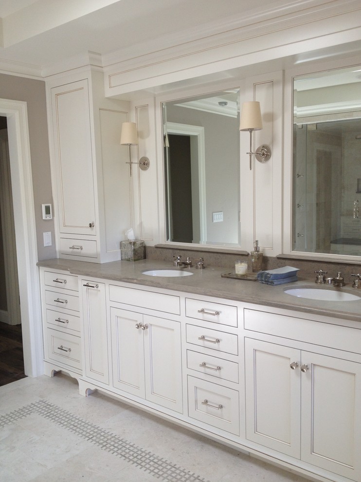 This is an example of a large classic ensuite bathroom in San Francisco with a submerged sink, recessed-panel cabinets, white cabinets, limestone worktops, a submerged bath, a double shower, a one-piece toilet, white tiles, marble flooring and beige walls.