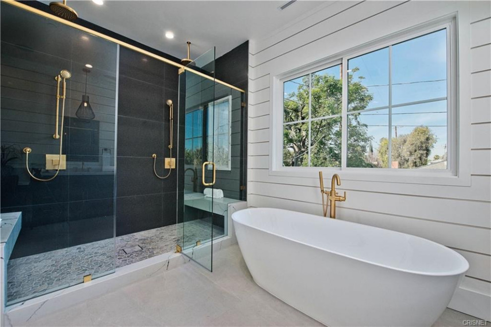 Пример оригинального дизайна: большая главная ванная комната в стиле модернизм с отдельно стоящей ванной, двойным душем, черной плиткой, белыми стенами, белым полом, душем с распашными дверями, сиденьем для душа и стенами из вагонки
