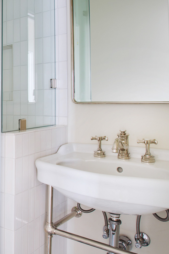 Immagine di una piccola stanza da bagno con doccia design con ante bianche, doccia ad angolo, WC monopezzo, piastrelle bianche, pareti bianche, pavimento con piastrelle in ceramica, lavabo a colonna, pavimento multicolore, porta doccia a battente, un lavabo e mobile bagno freestanding