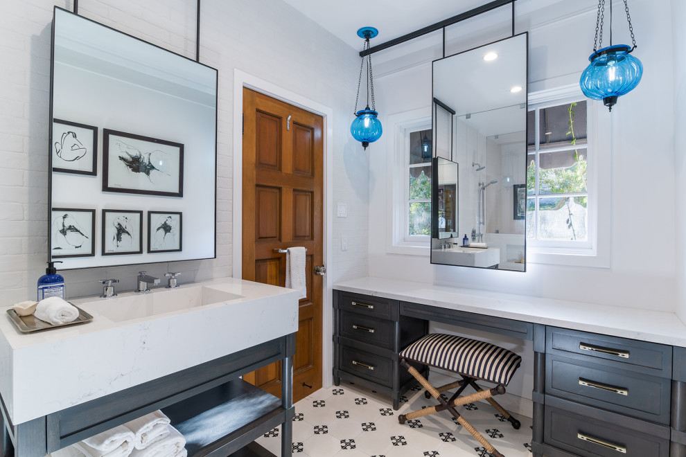 Medium sized classic bathroom in Los Angeles with dark wood cabinets, a one-piece toilet, white tiles, metro tiles, white walls, cement flooring, a vessel sink, solid surface worktops, white floors, a hinged door, white worktops, a single sink, a freestanding vanity unit and brick walls.