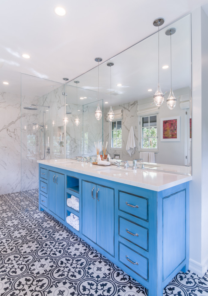 Large traditional ensuite bathroom in Los Angeles with flat-panel cabinets, blue cabinets, a claw-foot bath, a built-in shower, a one-piece toilet, black and white tiles, porcelain tiles, grey walls, cement flooring, a submerged sink, marble worktops, white floors, an open shower and white worktops.