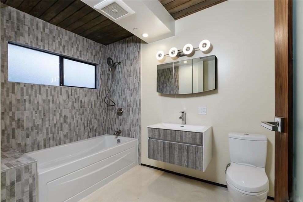 Пример оригинального дизайна: ванная комната среднего размера в стиле модернизм с плоскими фасадами, серыми фасадами, ванной в нише, душем над ванной, раздельным унитазом, серой плиткой, керамогранитной плиткой, белыми стенами, полом из линолеума, душевой кабиной и монолитной раковиной