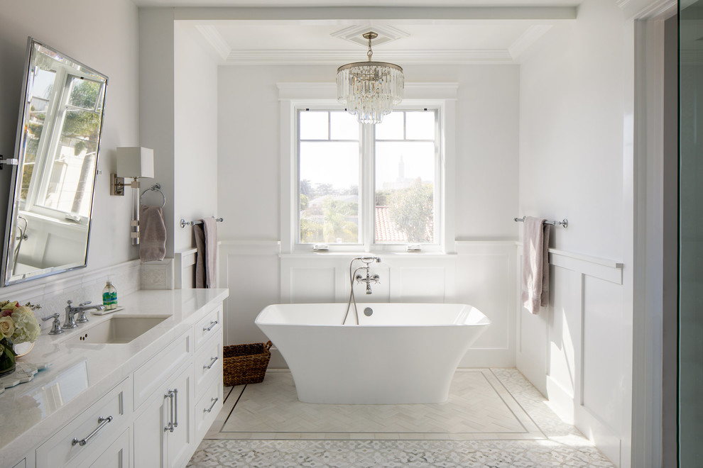 Esempio di una stanza da bagno american style con ante bianche, vasca freestanding, lavabo da incasso e top bianco