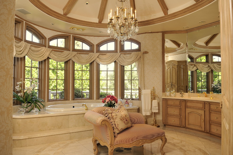 Immagine di una stanza da bagno padronale tradizionale con lavabo da incasso, consolle stile comò, ante in legno chiaro, top in onice, vasca da incasso, doccia doppia e pavimento in marmo