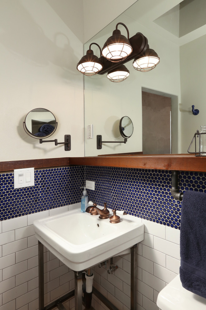 This is an example of a small industrial shower room bathroom in Los Angeles with an alcove shower, a one-piece toilet, blue tiles, white tiles, mosaic tiles, white walls, slate flooring, a wall-mounted sink and solid surface worktops.