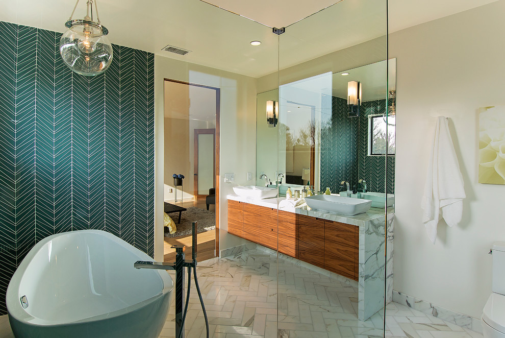 Modernes Badezimmer mit Aufsatzwaschbecken, flächenbündigen Schrankfronten, hellbraunen Holzschränken, freistehender Badewanne, bodengleicher Dusche, Wandtoilette mit Spülkasten und blauen Fliesen in Los Angeles