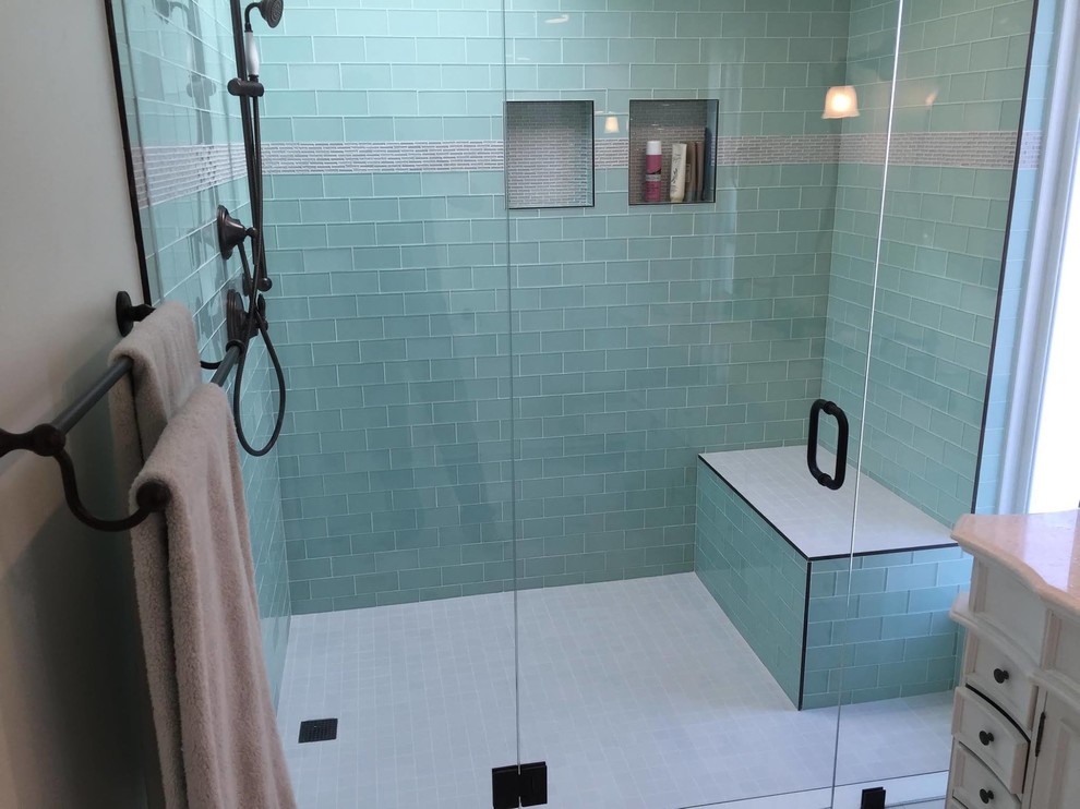 Maritim inredning av ett mellanstort badrum med dusch, med luckor med infälld panel, vita skåp, en dusch i en alkov, grå kakel, stickkakel, granitbänkskiva, beige väggar, klinkergolv i porslin och ett undermonterad handfat