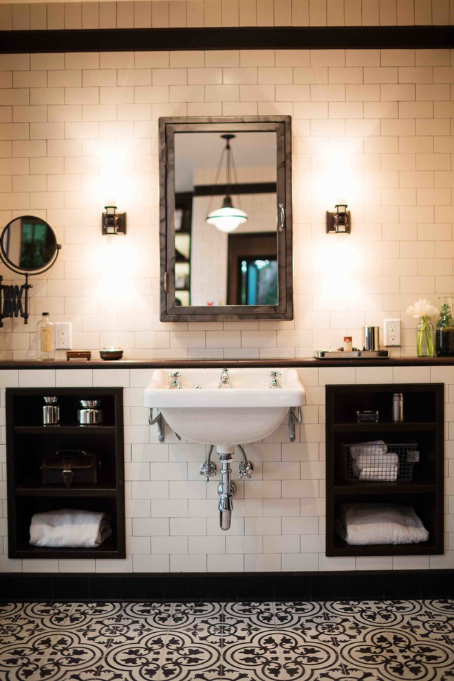 Diseño de cuarto de baño clásico con lavabo suspendido, armarios abiertos y baldosas y/o azulejos de cemento